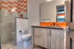 The en suite bathroom offers a fun, vintage pop of color with a walk in shower. 